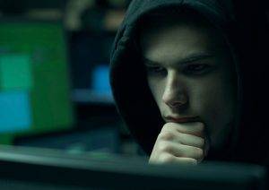 hacker with hoodie working with computers